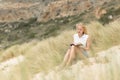 Woman reading book, enjoying sun on beach. Royalty Free Stock Photo