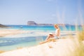 Woman reading book, enjoying sun on beach. Royalty Free Stock Photo