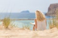 Woman reading book, enjoying sun on beach. Royalty Free Stock Photo