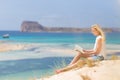 Woman reading book, enjoying sun on beach. Royalty Free Stock Photo