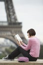 Woman Reading Book In Front Of Eiffel Tower