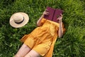 Woman reading book on green meadow, above view Royalty Free Stock Photo