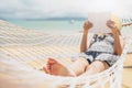 Woman reading a book on hammock beach in free time summer holiday Royalty Free Stock Photo