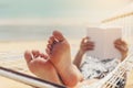 Woman reading a book on hammock beach in free time summer holiday Royalty Free Stock Photo