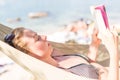 Woman reading book in hammock on the beach Royalty Free Stock Photo