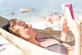 Woman reading book in hammock on the beach Royalty Free Stock Photo