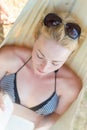 Woman reading book in hammock on the beach Royalty Free Stock Photo