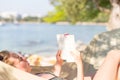 Woman reading book in hammock on the beach Royalty Free Stock Photo