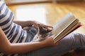 Woman reading a book and holding kitten Royalty Free Stock Photo