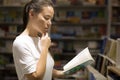 A woman reading a book in the library. Knowledge and self-improvement