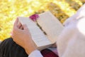 Woman reading book outdoors on sunny autumn day, closeup Royalty Free Stock Photo