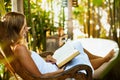 Woman reading book in outside bathroom