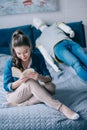 woman reading book while resting on bed with mannequin