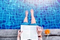 Woman Reading Book at the Swimming Pool Side, Relaxing with Summer Drink in her Vacation, Top View Royalty Free Stock Photo