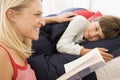 Woman reading book to young boy in bed smiling Royalty Free Stock Photo