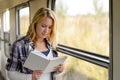 Woman reading a book by train window Royalty Free Stock Photo