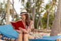 Woman reading a book under palm trees Royalty Free Stock Photo