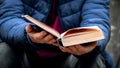 Woman reading a book in the woods. An elderly woman holding an open book