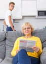 Woman reading booklet on sofa Royalty Free Stock Photo