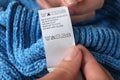 Woman reading clothing label with care symbols on knitted sweater, closeup Royalty Free Stock Photo