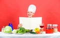 Woman reading cook book in kitchen. Girl cook at kitchen table ingredients. Tips and advice. Preparing food. Delicious Royalty Free Stock Photo