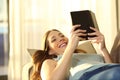 Woman reading e book lying on a couch