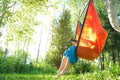 Woman reading e-book or using tablet while sitting in hammock chair on nature on sunset. Cottagecore, slow life in countryside, Royalty Free Stock Photo