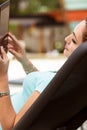 Woman reading eBook while relaxing on beach chair Royalty Free Stock Photo