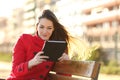 Woman reading an ebook or tablet in an urban park