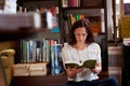 Woman, reading and floor in bookstore, library or relax for thinking for knowledge, information or literature. Girl Royalty Free Stock Photo