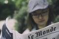 Woman reading french newspaper, Le Monde