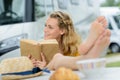 woman reading book in campervan campsite Royalty Free Stock Photo