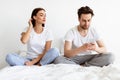 Jealous Woman Reading Husband's Messages While He Texting Indoors