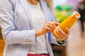 Woman reading ingredients and nutrition information on juice bottle