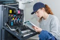 Woman reading instruction manual for photocopier Royalty Free Stock Photo