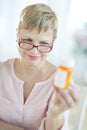 Woman Reading Instructions On Pill Bottle