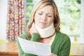 Woman Reading Letter After Receiving Neck Injury