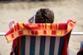 Woman reading magazine on beach in deckchair Royalty Free Stock Photo