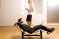 Woman reading man lying on chaise longue