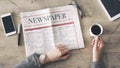 Woman reading newspaper and drinking coffee on table Royalty Free Stock Photo