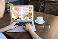 Woman reading online magazine on laptop in cafe, closeup Royalty Free Stock Photo