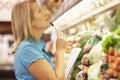 Woman Reading Shopping List In Supermarket Royalty Free Stock Photo