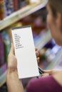 Woman Reading Shopping List In Supermarket Royalty Free Stock Photo