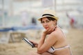 woman reading tablet reader on the beach