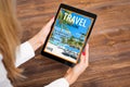 Woman reading travel magazine on tablet