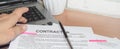 A woman reads and analyzes the contract, making notes on it with colored stickers, a workplace with a laptop, a pen Royalty Free Stock Photo