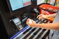 Woman reads the bar code of instant noodles soup at the self-service checkout machine in supermarket
