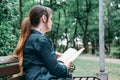 Woman reads the bible in the park on a bench. The biblical concept of God is based on faith and spirituality