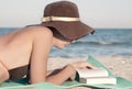 Femme lit livre sur plage 