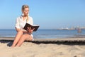 Woman reads a book on the beach Royalty Free Stock Photo